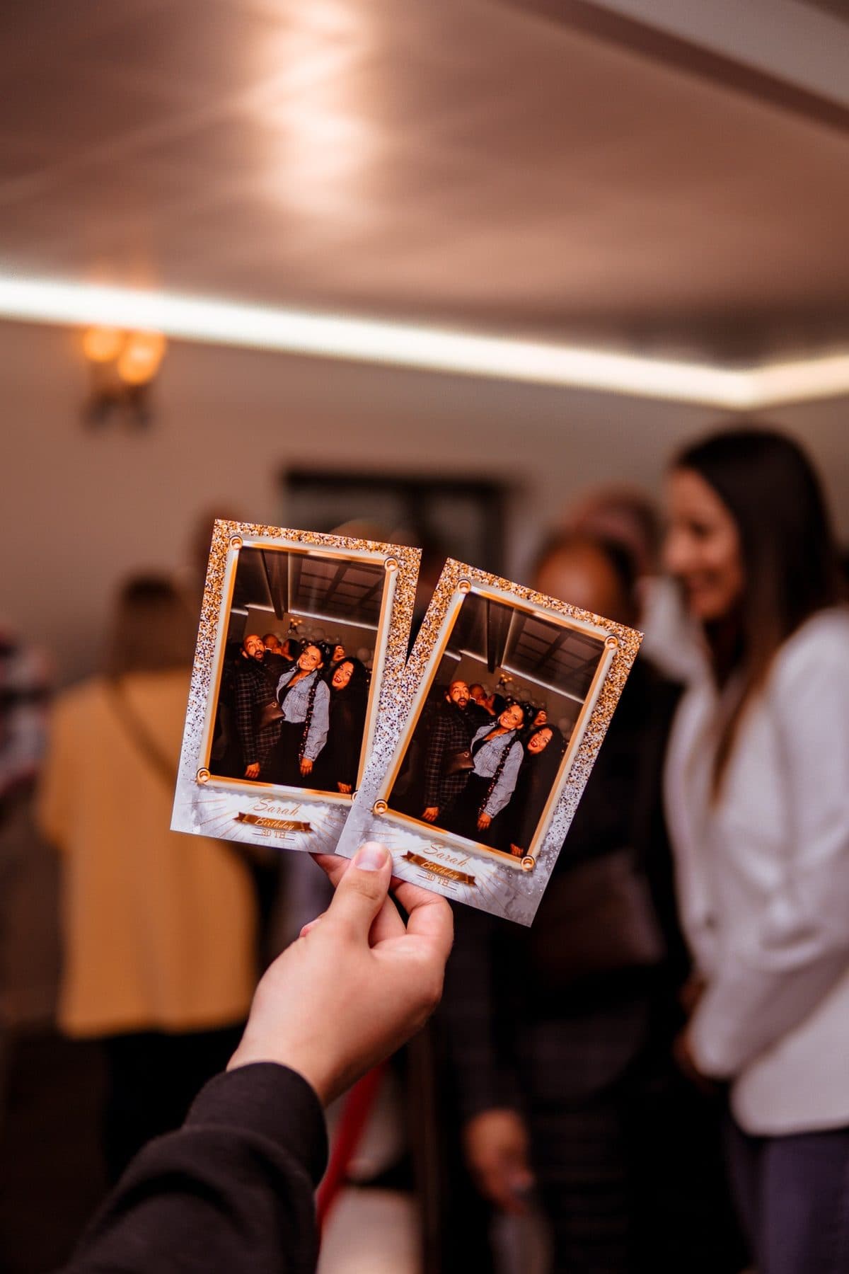 Deux tirages photo au cadre personnalisé, tenus devant les invités